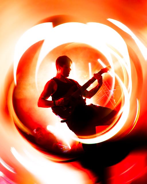 Guitarist inside an orange light swirl